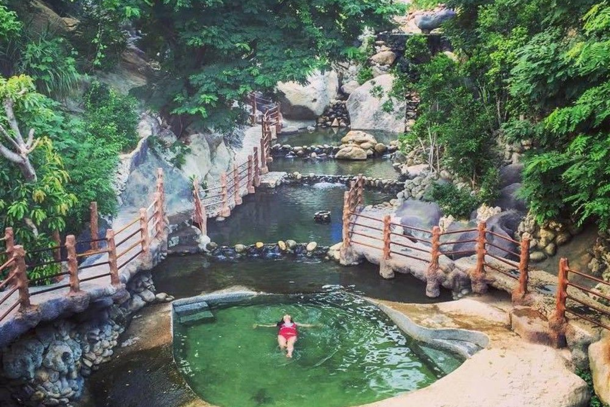 Steam rising from Hua Pe Hot Spring near Dien Bien Phu with lush surroundings
